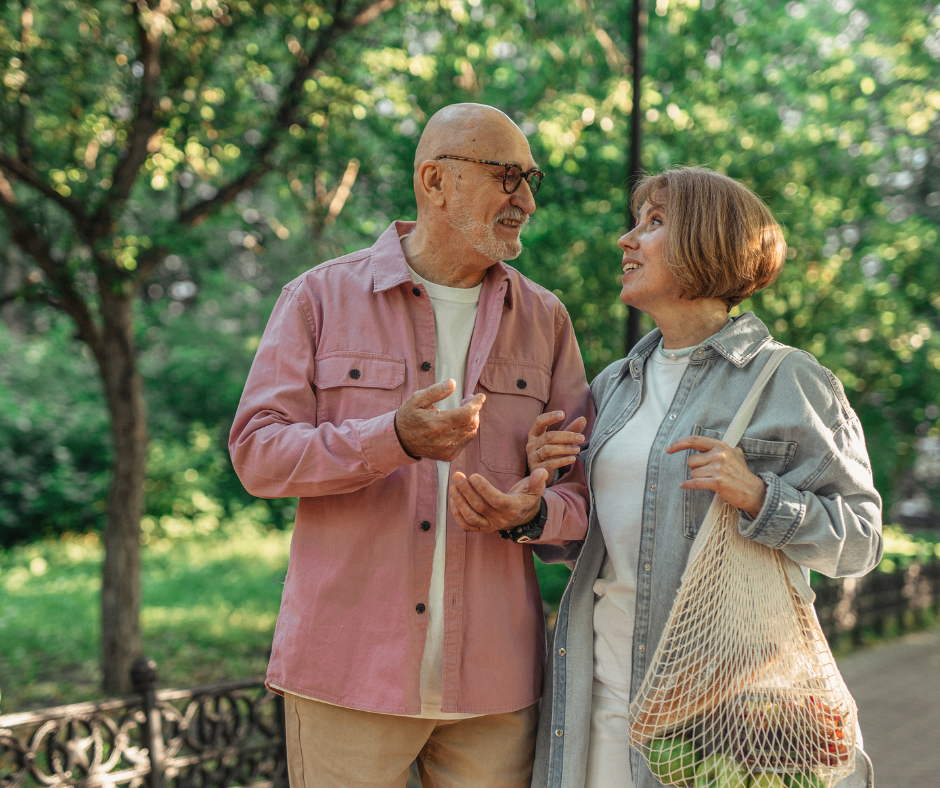 a man and woman talking in a park about how fall prevention is impacted in senior living.